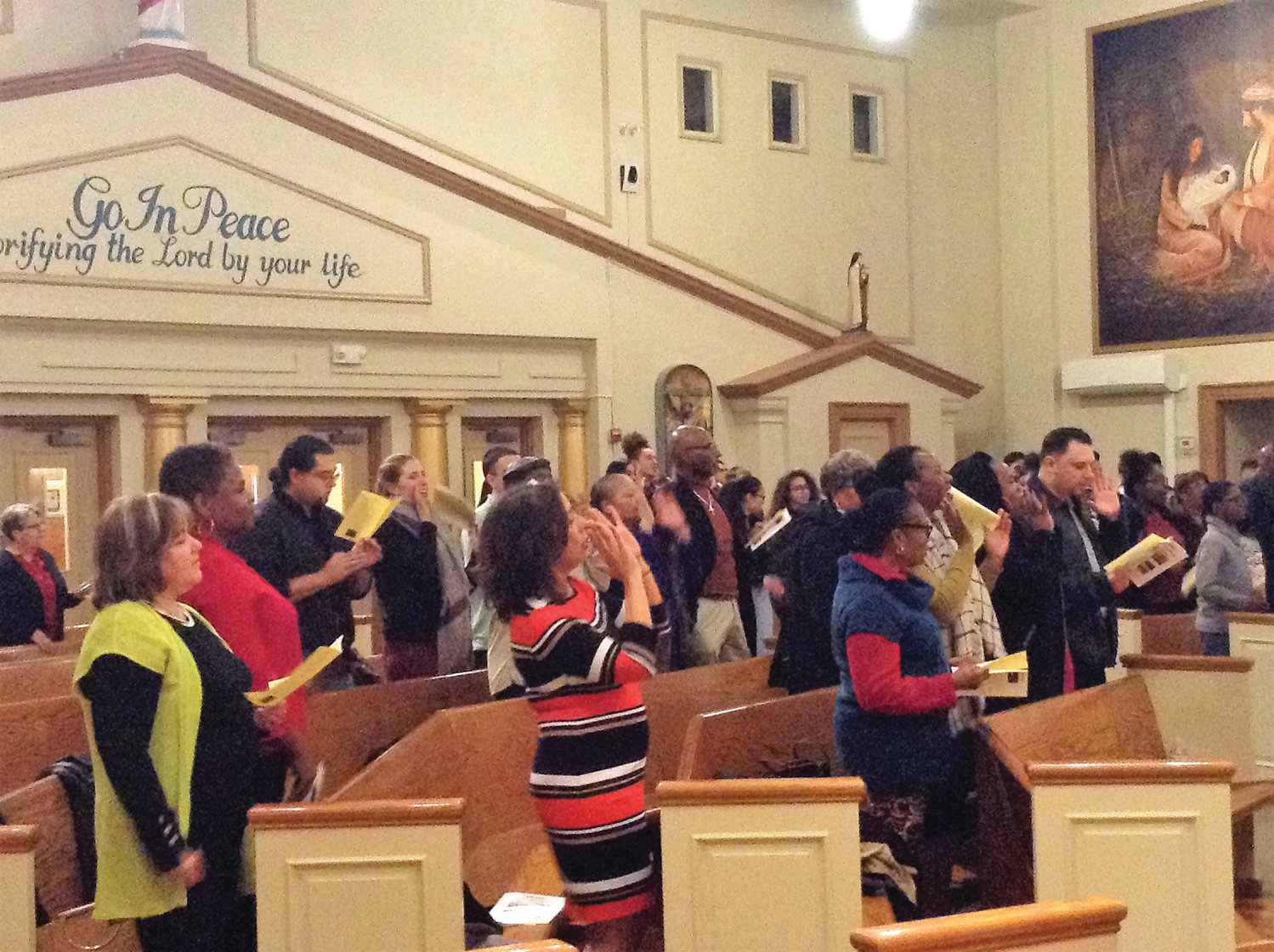 The crowd at the recent Black History Month celebration at St. Patrick Church, Providence, performs a simple dance together while singing “Ain’t Gonna Let Nobody Turn Me Around.”  The celebration was originally scheduled for February 12, but inclement weather forced a postponement.